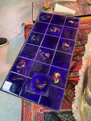 a table with a tray of blue tiles on it