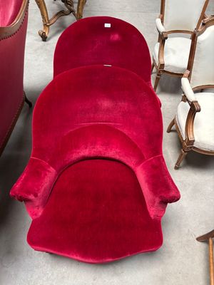 une chaise rouge qui se trouve dans une pièce où il y a beaucoup de chaises