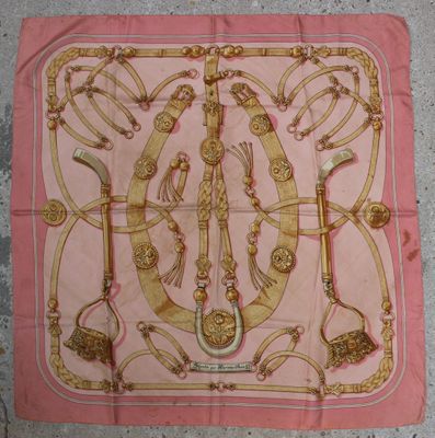 écharpe rose et dorée sur laquelle est représenté un sac à main de femme