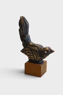 statue of a bird on a wooden base on a white background