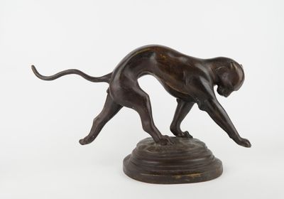 bronze statue of a dog running on a pedestal
