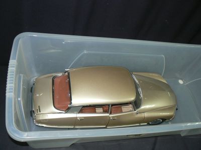 une petite voiture dans un récipient en plastique posé sur une surface noire