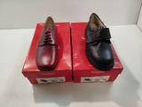 deux paires de chaussures noires et rouges posées sur une boîte rouge