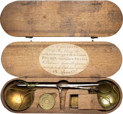 une boîte en bois contenant une paire de ciseaux et une paire de ciseaux
