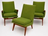 two green chairs and a foot stool in a white room