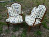 une paire de chaises anciennes avec des coussins rembourrés à motifs floraux, dans un champ