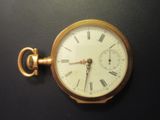 une montre de poche en or avec des chiffres romains