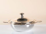 a silver pot with a lid sitting on a table