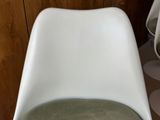 a white chair with a green seat in a room