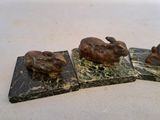 three statues of animals on marble blocks on a table