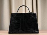 the small black bag is sitting on a table with a curtain in the background