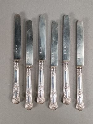 six silverplated knives are lined up next to each other on a table