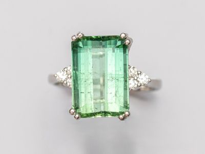 un gros plan d'une bague en tourmaline verte et diamants