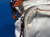 a white bag with a zipper on it on a blue surface