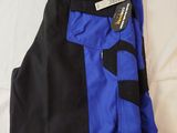 blue and black pants on a bed with a tag on it