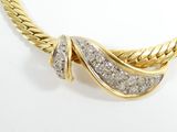 a close up of a gold and diamond necklace on a white background