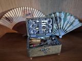 une boîte en bois contenant un trousseau de clés et un ventilateur