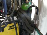 a green and black welding machine in a garage