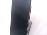 a black cell phone sitting on top of a stand