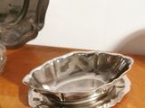 a silver plate and a silver bowl on a wooden table