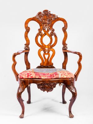 une chaise en bois avec une assise et des accoudoirs rembourrés d'un motif floral