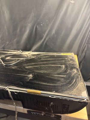 une boîte noire munie d'une poignée jaune, posée sur une table en bois