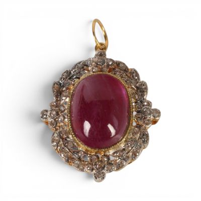 un gros plan sur un pendentif en pierre rouge et diamants