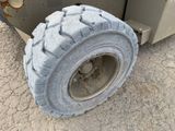 a tire that is sitting on the ground next to a truck