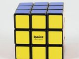 a black and yellow rubik cube sitting on top of a white table
