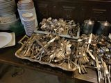 a lot of silver spoons and forks on a table