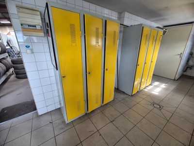 Des casiers jaunes sont alignés les uns à côté des autres dans des toilettes publiques