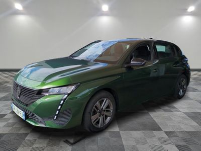 the green car is parked on a checkered floor in a room