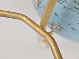 a blue and gold globe with a gold stick sticking out of it