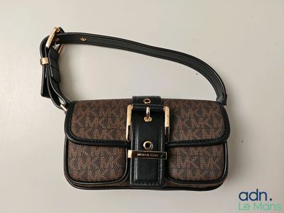 a brown and black purse sitting on top of a white table