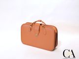 une valise beige posée sur une surface blanche