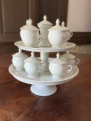 a three tiered plate with cups and saucers on it