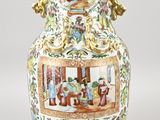 a vase with a painting on it sitting on a table