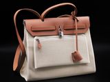 a close up of a white and tan bag with a brown handle