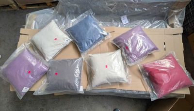 many bags of different colored pillows on a cardboard box