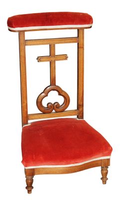 une chaise en bois avec une assise rouge et une croix sur le dossier