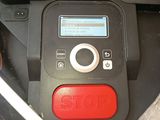 a red button on the side of a black lawn mower