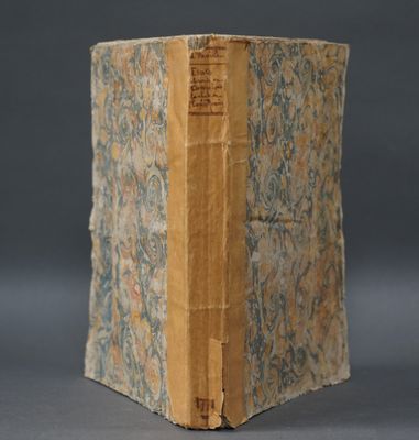 un vieux livre posé sur une table recouverte de papier