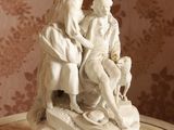 une statue représentant un homme et une femme assis sur une table