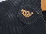 black cordurope shirt with a gold embroidered bird on the chest