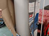 un homme debout à côté d'un carton contenant des toilettes