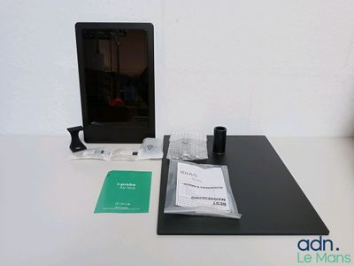 a laptop computer sitting on top of a desk next to a cup