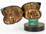 a gold sculpture of a man and a woman on a pedestal