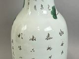 a white vase with asian writing on it sitting on a table