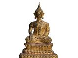 une statue de Bouddha dorée, assise sur un socle blanc