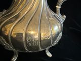 un pichet en argent posé sur une table